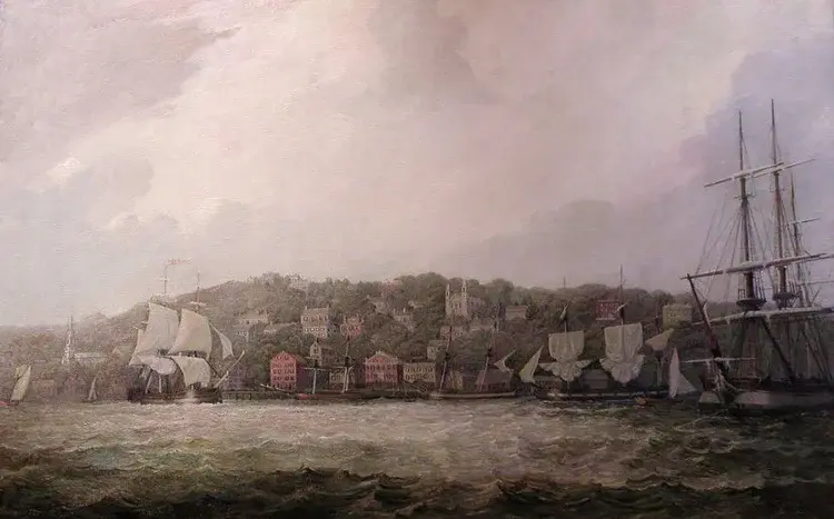 Sailing ships in a harbor with a colonial town on a hillside, reflecting 18th-century life in Rhode Island.